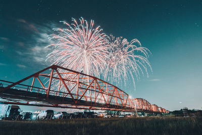 Low angle view of bridge over river against sky at night