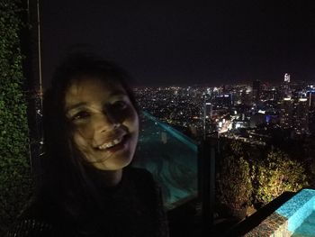 Portrait of woman in city at night