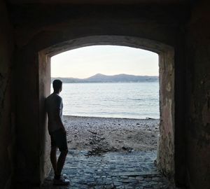 Man standing by sea against sky