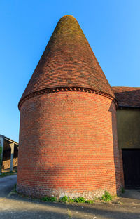 Low angle view of old building against clear blue sky