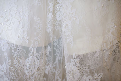 Part of an ivory wedding dress. french lace on the bride's dress with beads