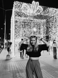 Portrait of young woman standing in city