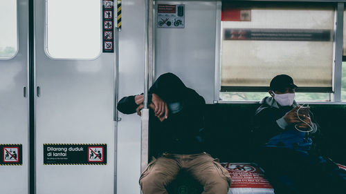 Rear view of people sitting in train