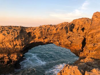 Scenic view of rocks in sea against sky