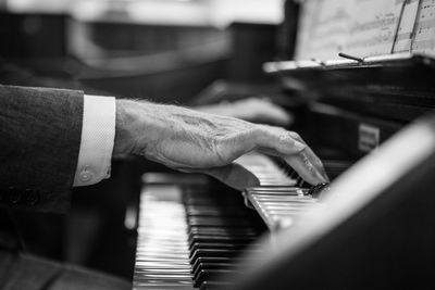 Side view of hand playing the piano