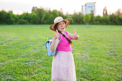 Portrait of smiling woman standing on field