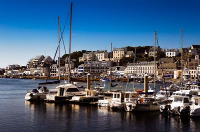 Sailboats moored in harbor