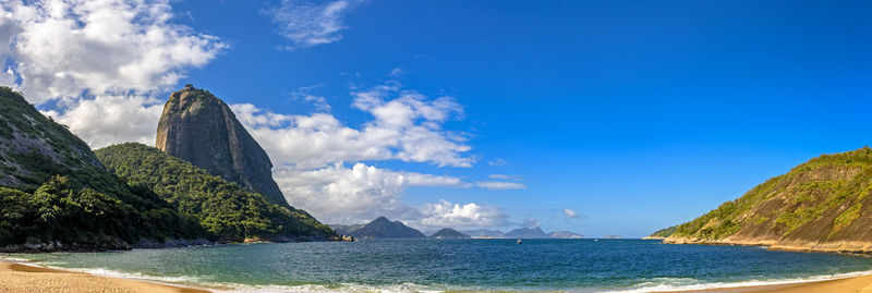 Panoramic view of sea and sugarloaf hill against cloudy sky