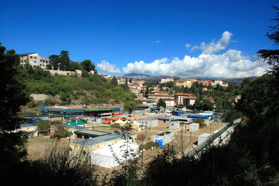 High angle view of town against blue sky