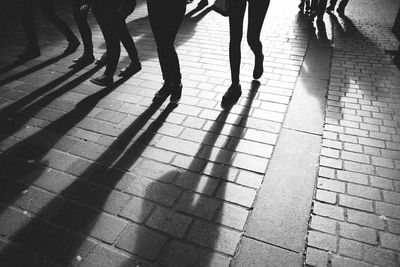 Low section of people standing on tiled floor