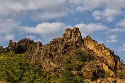 Low angle view of rock formation against sky