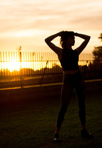 Full length of woman standing against sky during sunset