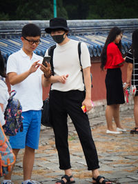 Group of people using mobile phone in city