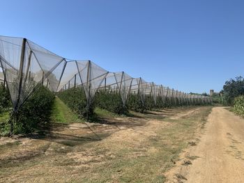 Road by land against clear blue sky