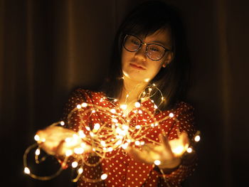 Close-up of woman holding burning candle