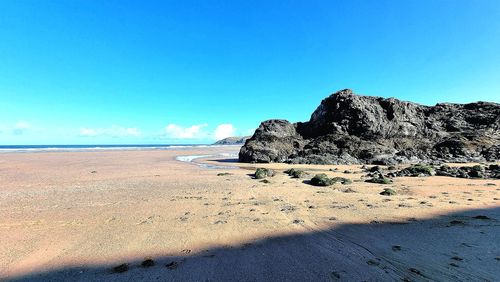 Scenic view of beach against blue sky