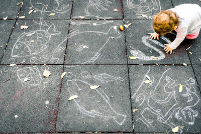 High angle view of child playing on footpath