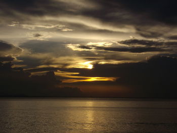 Scenic view of sea against dramatic sky during sunset