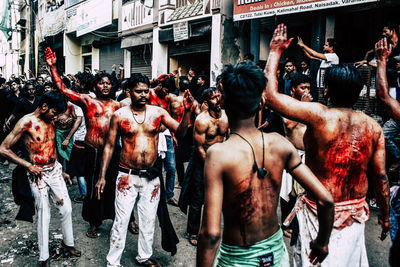 Rear view of people standing on street in city