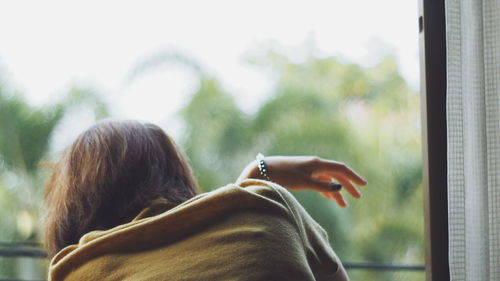 Rear view of woman holding hair