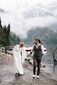 A happy couple in love and married embrace in nature by the lake and the misty mountains