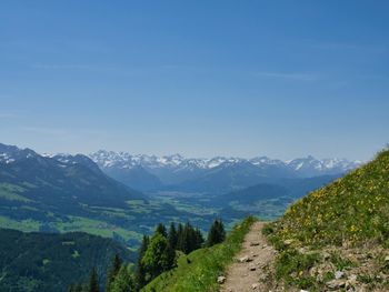 Scenic view of landscape and mountains against blue sky