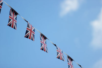 Low angle view of flag flags against blue sky