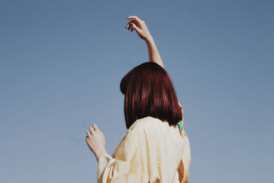 Low angle view of woman against clear sky