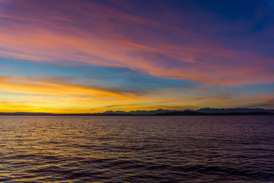 Scenic view of sea against dramatic sky during sunset