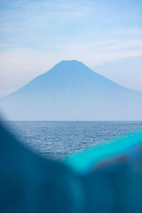 Scenic view of sea and mountains against sky