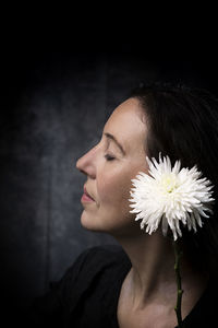Woman in melancholic attitude with white chrysanthemum vii