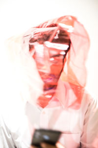 Close-up of human hand holding drink against white background