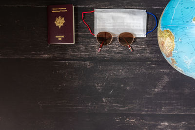 World map and items on wooden background, flat lay. summer travel wanderlust concept, space for text