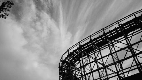 Low angle view of silhouette rollercoaster against sky