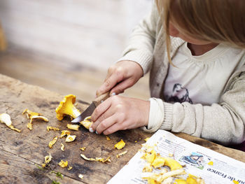 Girl cutting chanterelle, close-up