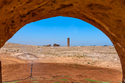 Built structure on land against clear sky seen through hole