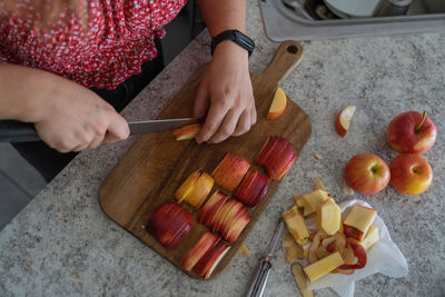 High angle view of young adult women cutting apples on the wood board