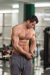 Shirtless man exercising in gym