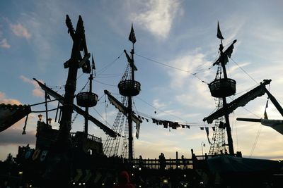 Low angle view of silhouette cranes against sky during sunset