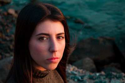 Close-up portrait of young woman by sea