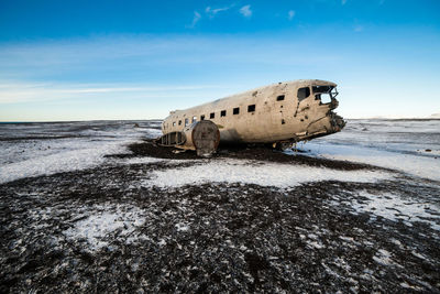Abandoned airplane on beach during winter