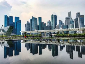 Reflection of buildings in city against sky