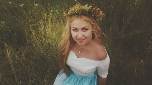 Portrait of young woman standing on field