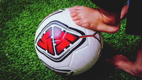 Close-up of hand holding ball on field