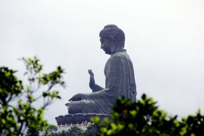 Low angle view of tian tan buddha against sky