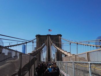 People on bridge against clear sky