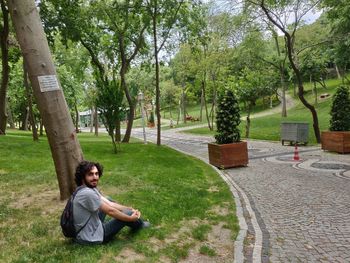 Portrait of man sitting on land in park