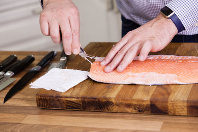 Cropped image of man cleaning fish