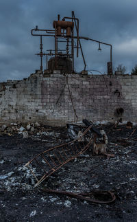 Abandoned machinery on field against sky