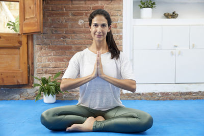 A cross-legged woman doing a yoga pose. self confident.